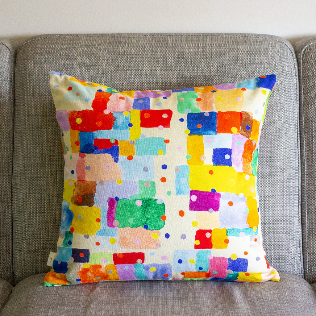 Colorful geometric-patterned cushion on a gray sofa