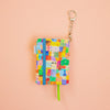 Colourful patterned keychain with a small notebook on a peach background