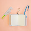 Open notebook with a keychain and ruler on a peach background