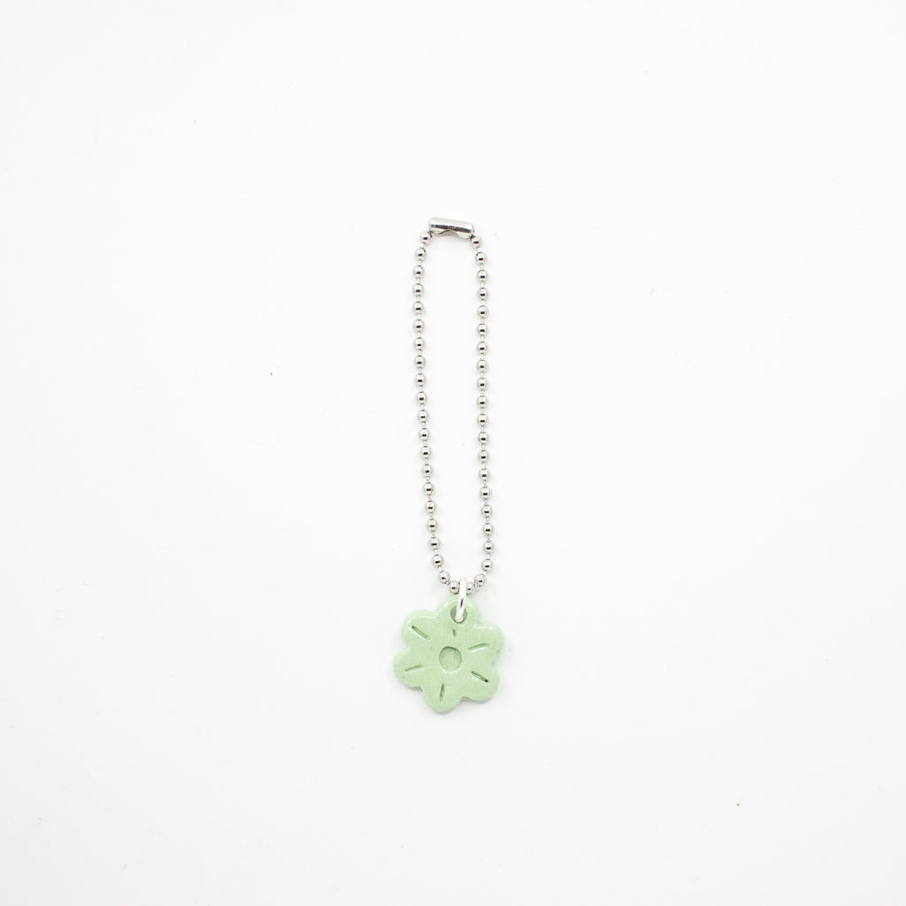 Keychain with a green flower charm on a white background