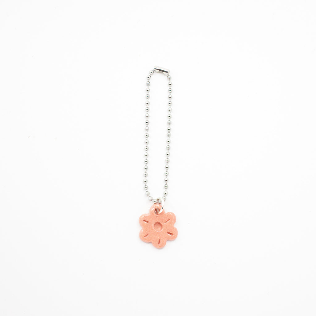 Keychain with a pink flower charm on a white background