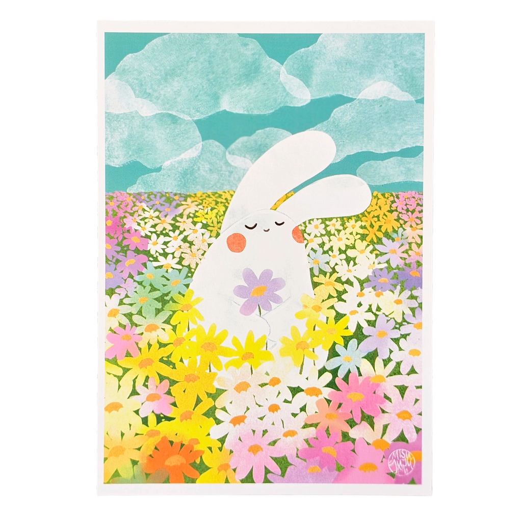 An art print featuring a cute white bunny standing in a colourful field of flowers under a teal sky with clouds. The print has a white border and is shown against a white background.