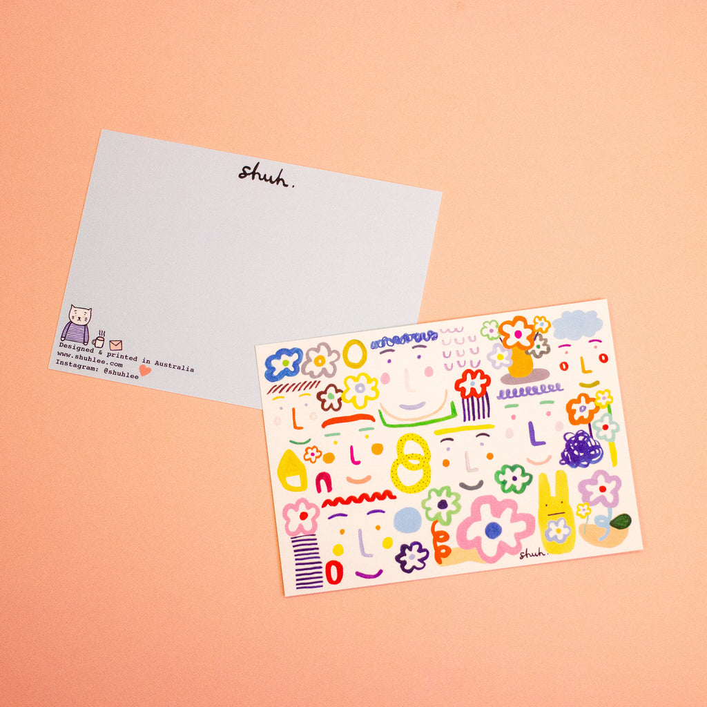 Two rectangular postcards. One featuring the front colourful illustrations with a white background. The other postcard shows the back with a light blue background and shuh. logo on the top. Both postcards are photographed on a peach backdrop. 