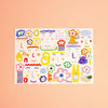 A rectangular postcard featuring colourful illustrations with a white background photographed on a peach backdrop. 