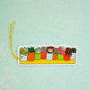 A die-cut sticker featuring a row of colorful potted plants, complete with a yellow hanging loop, displayed on a textured mint green background.