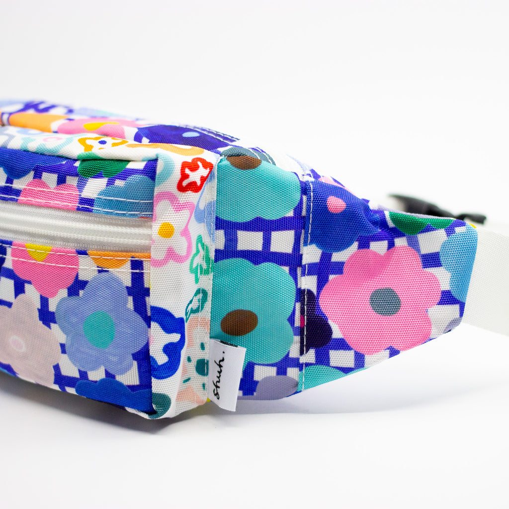 Colorful floral-patterned bum bag with a visible brand label on a white background