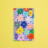 A sticker with a colourful floral pattern, displayed flat against a solid yellow background.