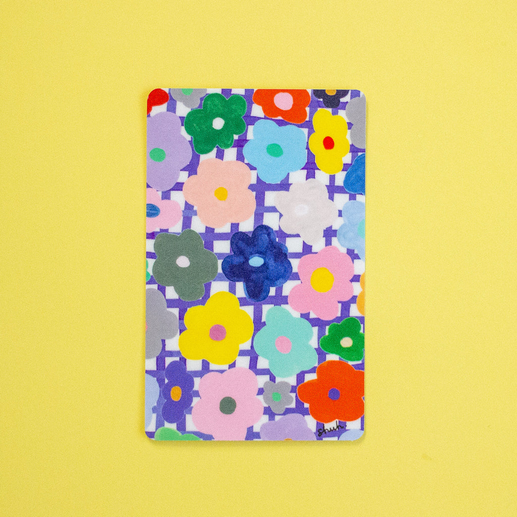 A sticker with a colourful floral pattern, displayed flat against a solid yellow background.