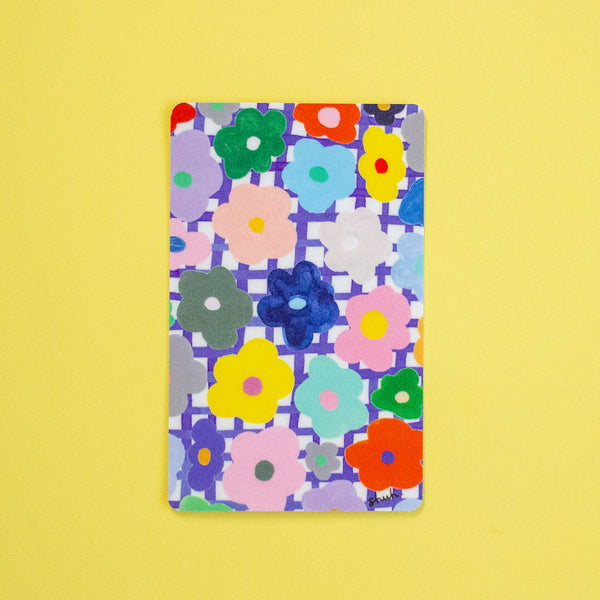 A sticker with a colourful floral pattern, displayed flat against a solid yellow background.