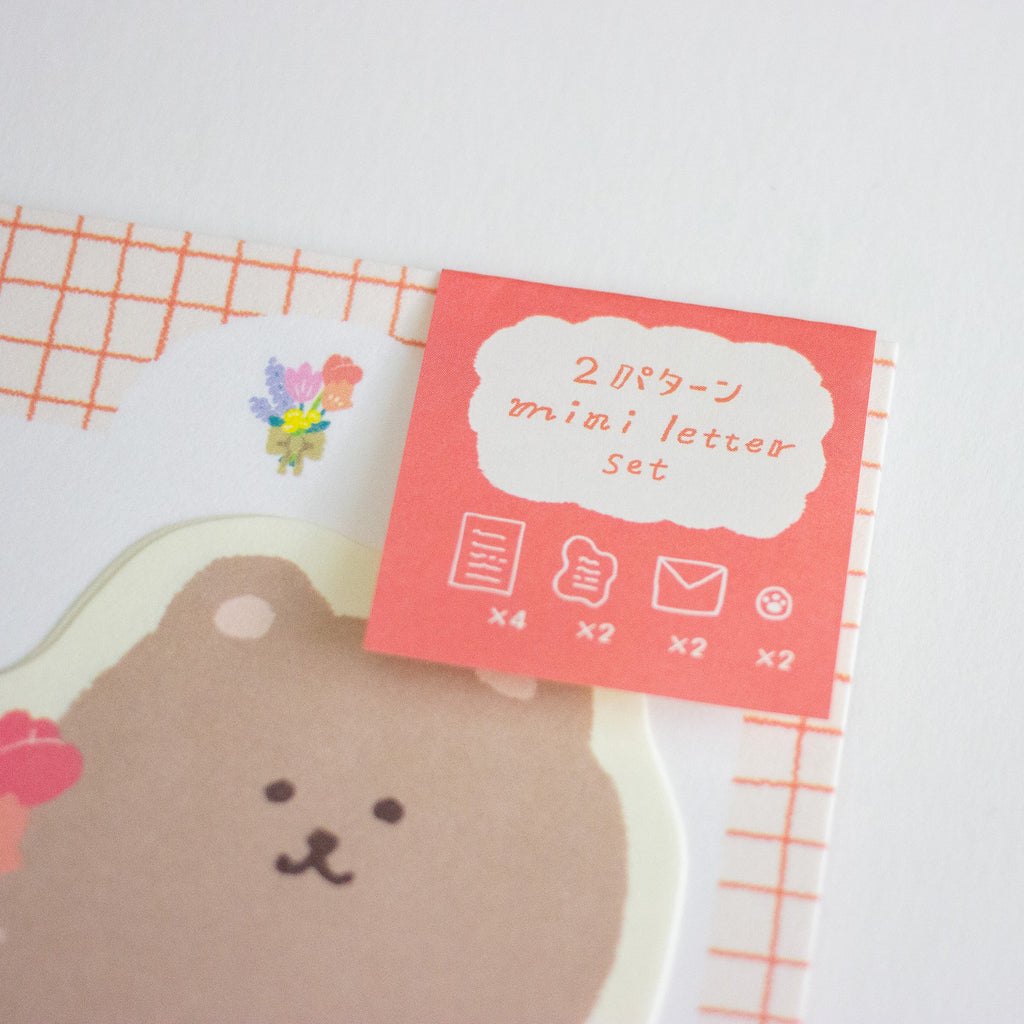 A mini letter set with cute bear-themed stationery, featuring a red-orange card labeled '2 mini letter set' over a white background with a grid pattern and a bear illustration.