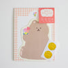A cute bear-shaped stationery set featuring a tan bear-shaped paper with a floral design, a coral-coloured header card, and two gold paw-shaped seals on a white backing sheet, all displayed on a light grey background.