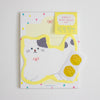 A cute cat-shaped stationery set featuring a white cat with grey ears and a yellow border, a yellow letterhead, and two gold paw-print stickers on a white background.