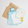 A stationery set laid out on a light grey background, including kraft paper envelopes, light blue striped letterheads, a white die-cut letterhead with a cartoon dog outline, a small blue card, and two round paw gold stickers.