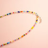 Colourful beaded necklace on a peach background