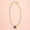 Colouful beaded necklace with a pendant on a peach background