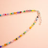 Colourful beaded necklace on peach background