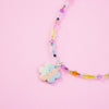 Colourful beaded necklace with a flower-shaped pendant on a pink background