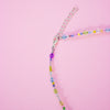 Colourful beaded necklace on a pink background