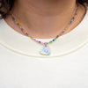Necklace with a heart-shaped pendant worn by a person on a cream background