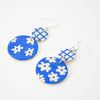 Blue and white floral patterned earrings on a white background