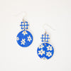 Blue earrings with white floral patterns on a white background