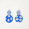 Blue earrings with white floral patterns on a white background