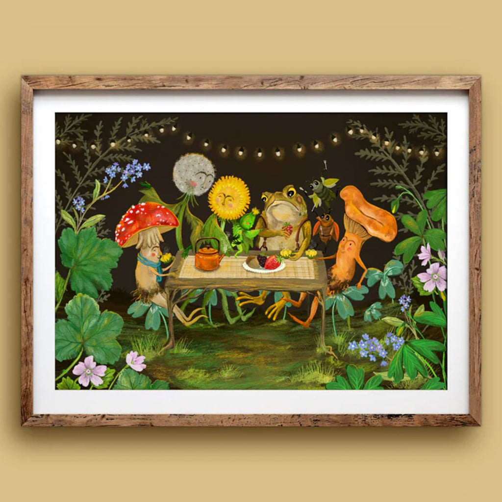 Framed artwork of a whimsical scene with animals around a table in a forest setting.