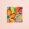Colorful floral patterned fabric coaster on a light pink background