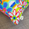 Colorful floral-patterned product with a 'shuh' tag on a textured surface