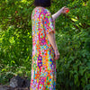 Person wearing a colorful floral linen dress standing in a garden
