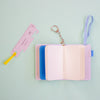 Small notebook with plain pages and light blue elastic on a light green background.
