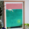 A framed art print featuring a stylised white goose on a green field under a pink sky, displayed on a wooden shelf next to a glass vase with leaves and small goose figurines.