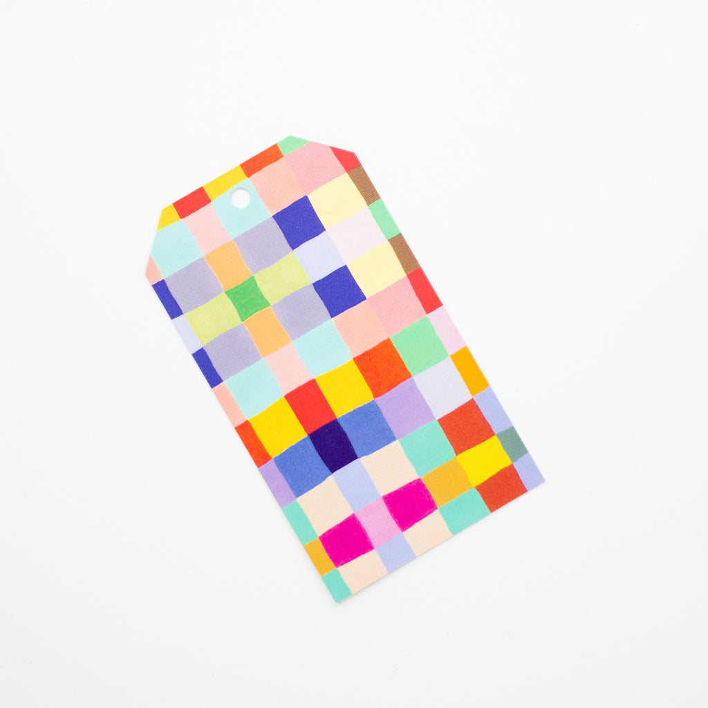 A closeup picture of the squares gift tag. Print features multicoloured hand drawn squares, creating a vibrant chequered pattern. 