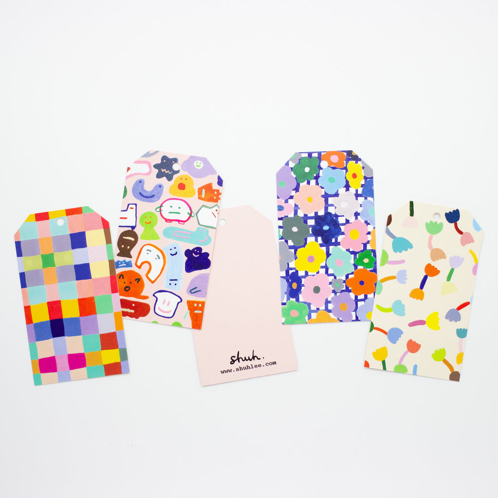 A photo of the collection of shuh. gift tags, with 5 different vibrant multicoloured artistic prints. 
