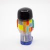 Back view of a handmade ceramic figurine featuring a black bob haircut, colourful patchwork shirt, vertical striped pants, and blue shoes. Designed by shuh.