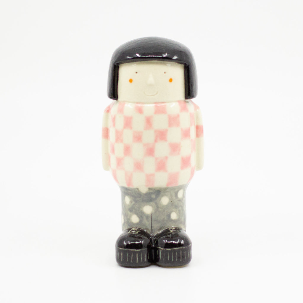 A Frontview of the girl figurine number 6 with chequered pattern. 