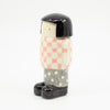 A Side view of the girl figurine number 6 with chequered pattern. 