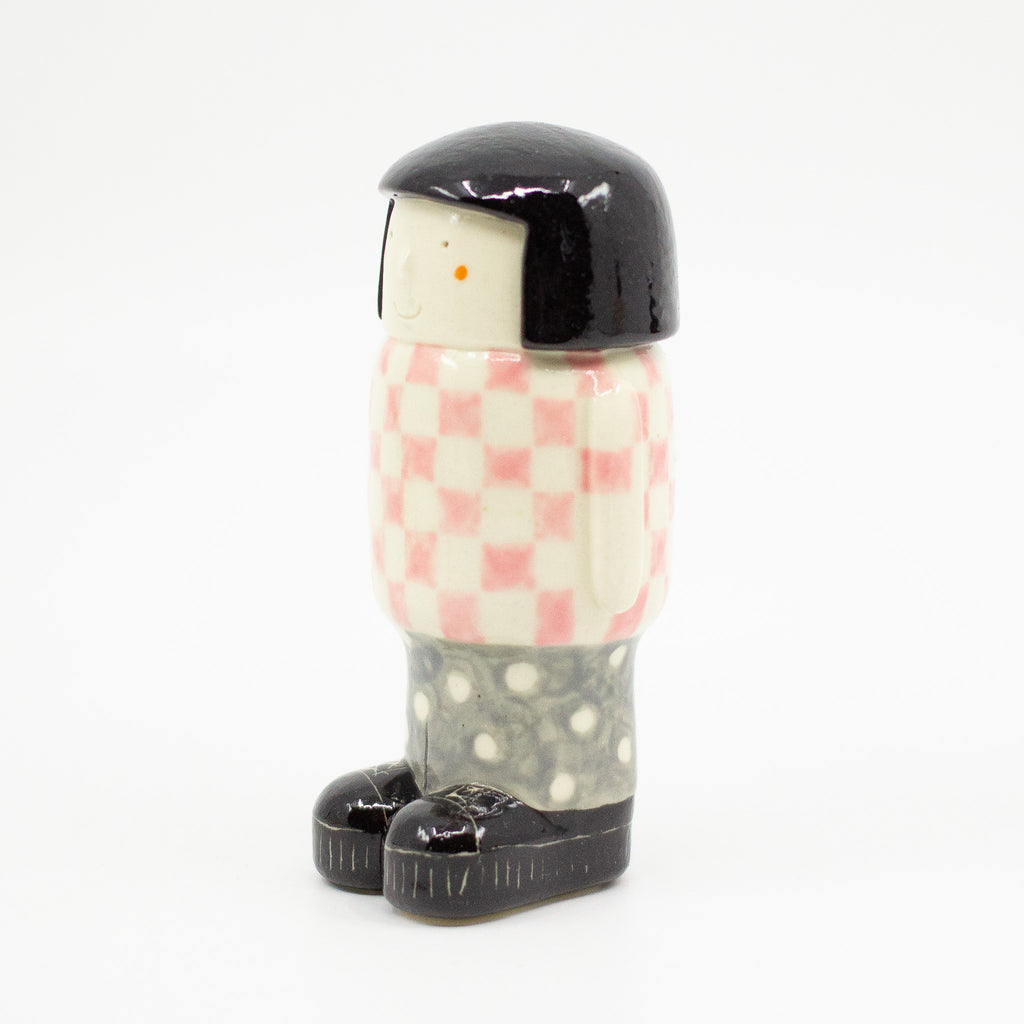 A Side view of the girl figurine number 6 with chequered pattern. 