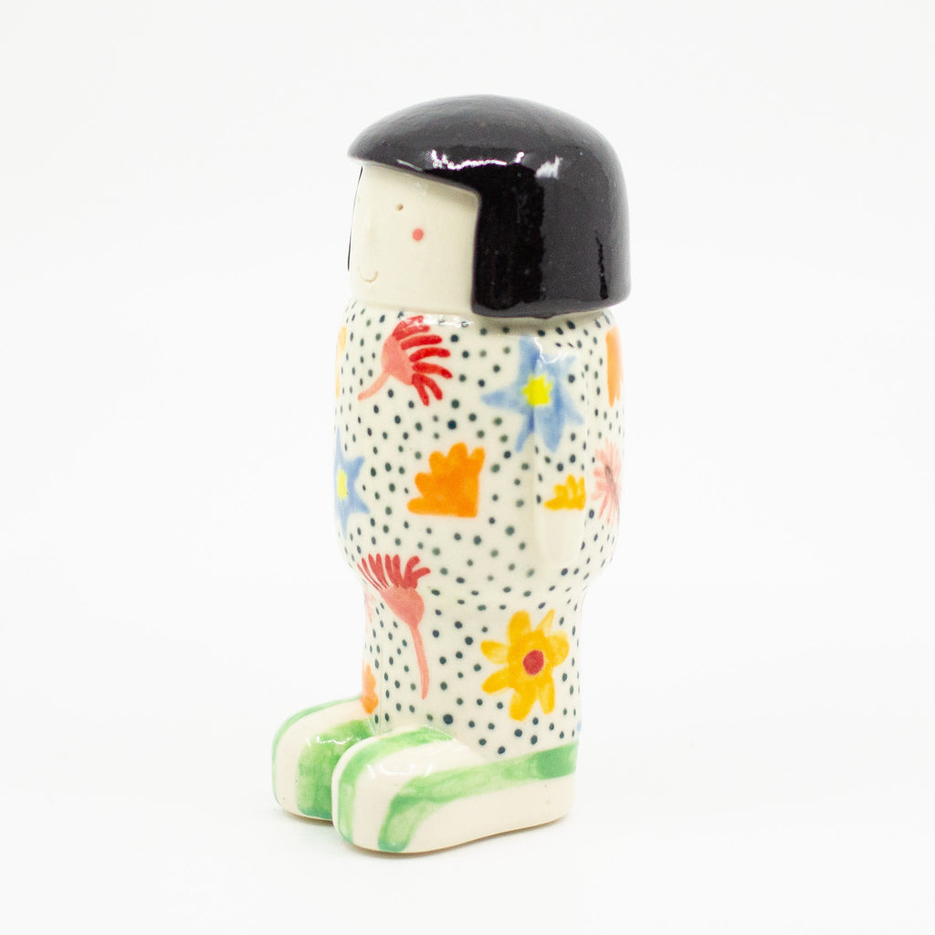 A Side view of girl figurine number 8, with floral pattern. 