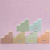 Set of colorful smiley face ceramic figurines  on a pink background