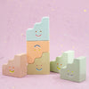 Set of colorful ceramic figurines with smiley faces on a pink background