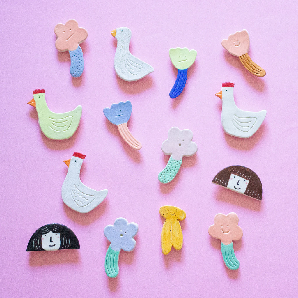 A top view of the Garden Day magnets collection - including ducks, flowers, a banana, and girls head