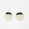 Pair of handmade ceramic earrings by shuh. featuring smiling faces with raised noses, rosy cheeks, and black hair, finished with silver hooks and displayed on a white background.
