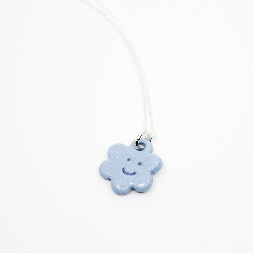 Necklace with a blue flower-shaped pendant on a white background