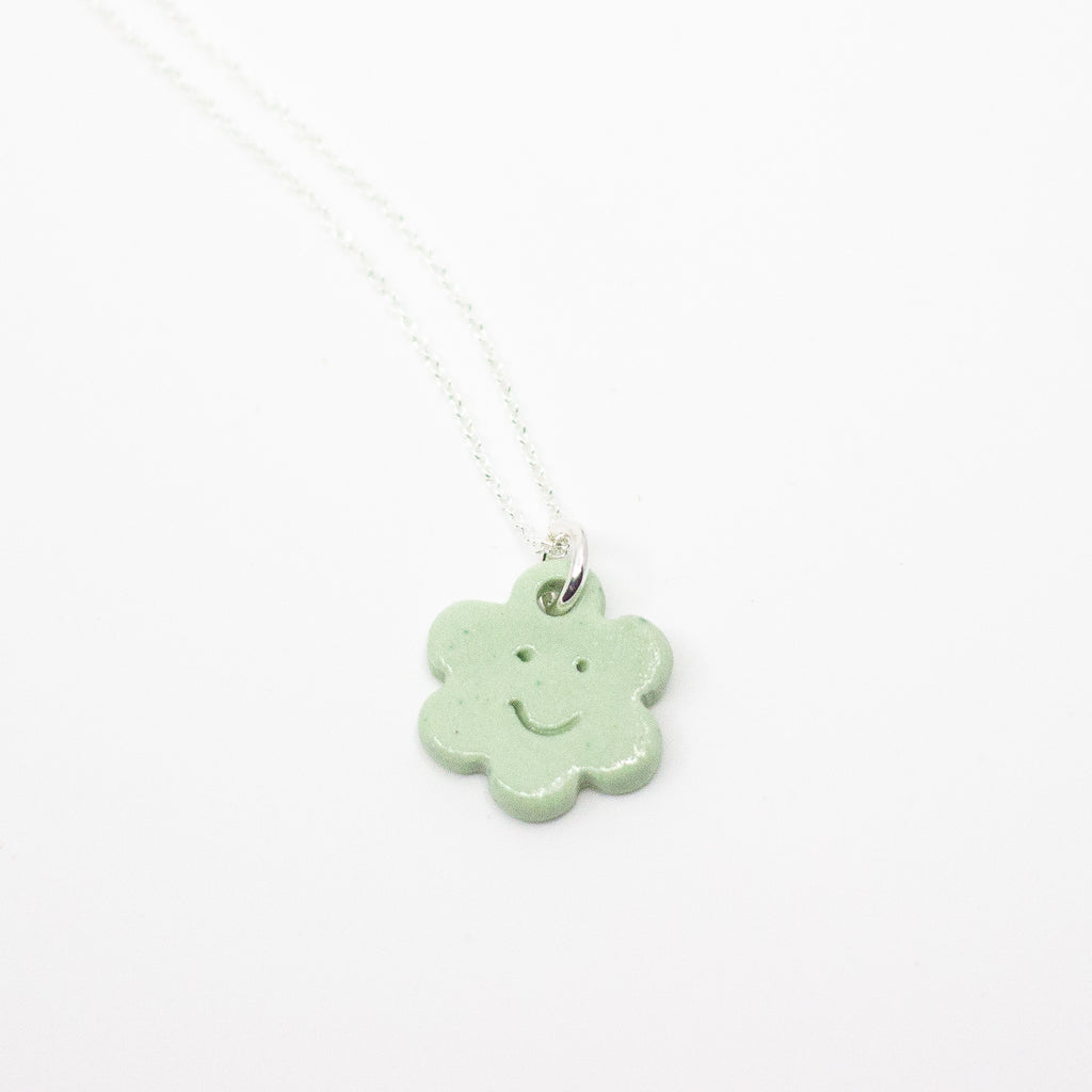 Necklace with a green flower-shaped pendant on a white background