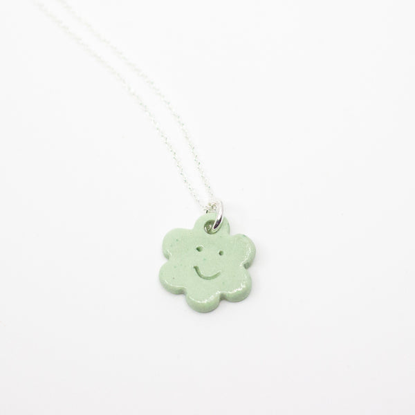 Necklace with a green flower-shaped pendant on a white background