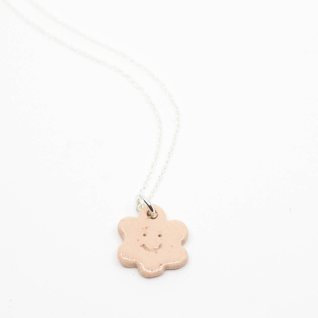 Necklace with a smiley face pendant on a white background