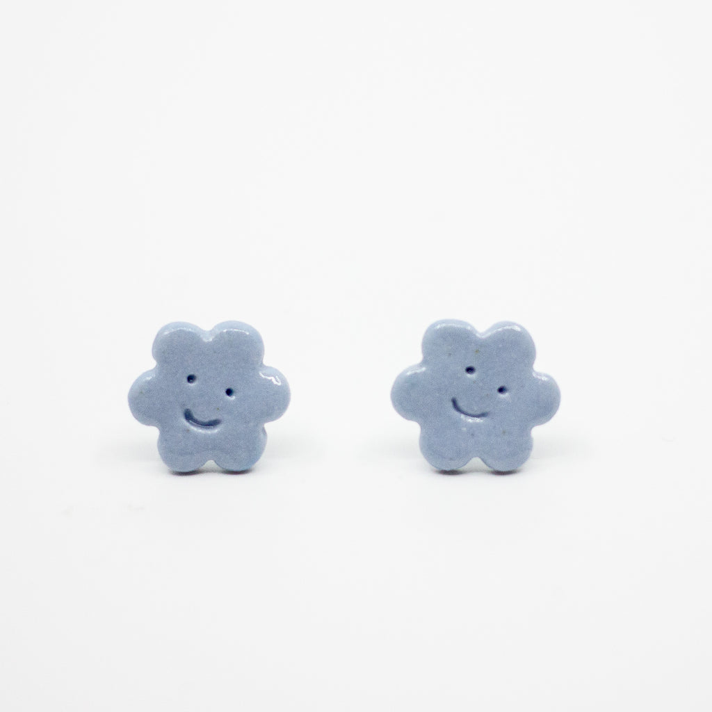 Pair of blue flower-shaped earrings on a white background