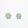 Pair of green flower-shaped earrings on a white background