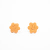 Two orange flower-shaped earrings on a white background